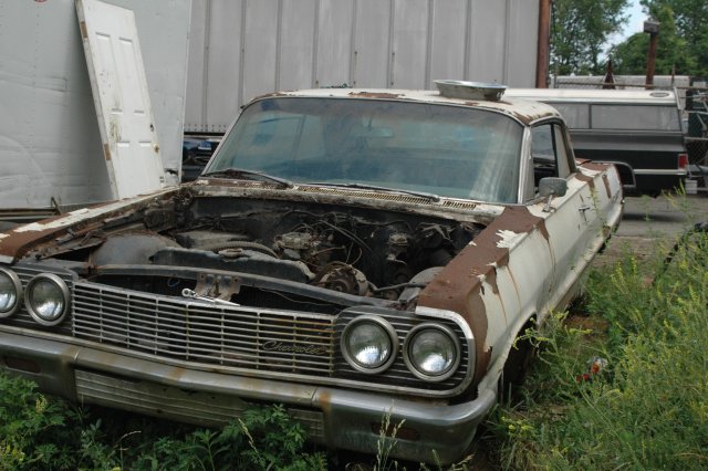 A pretty rusty 64 Impala before stripping parts from it